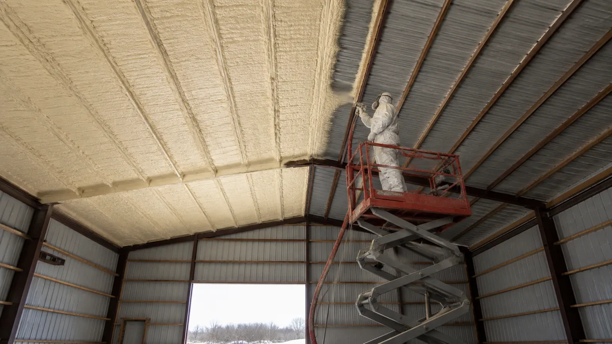 Closed cell foam going up under a pole barn roof deck, sprayed by insulation contractors serving Eaton CO