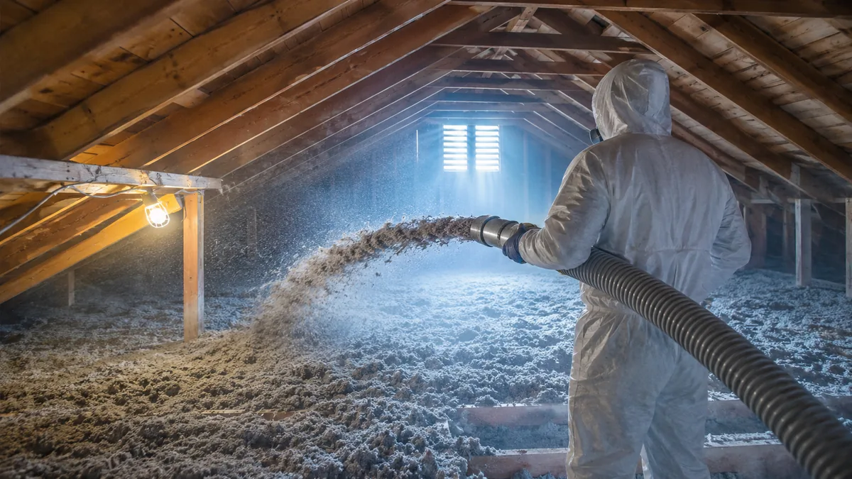 Cellulose being blown across an attic floor on a winter morning by insulation contractors in Greeley CO