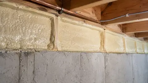Rigid closed cell foam covering a rim joist