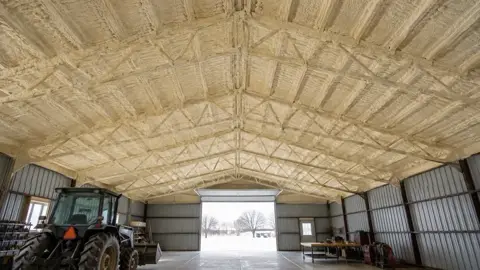 Spray foam on the steel roof deck of a pole barn